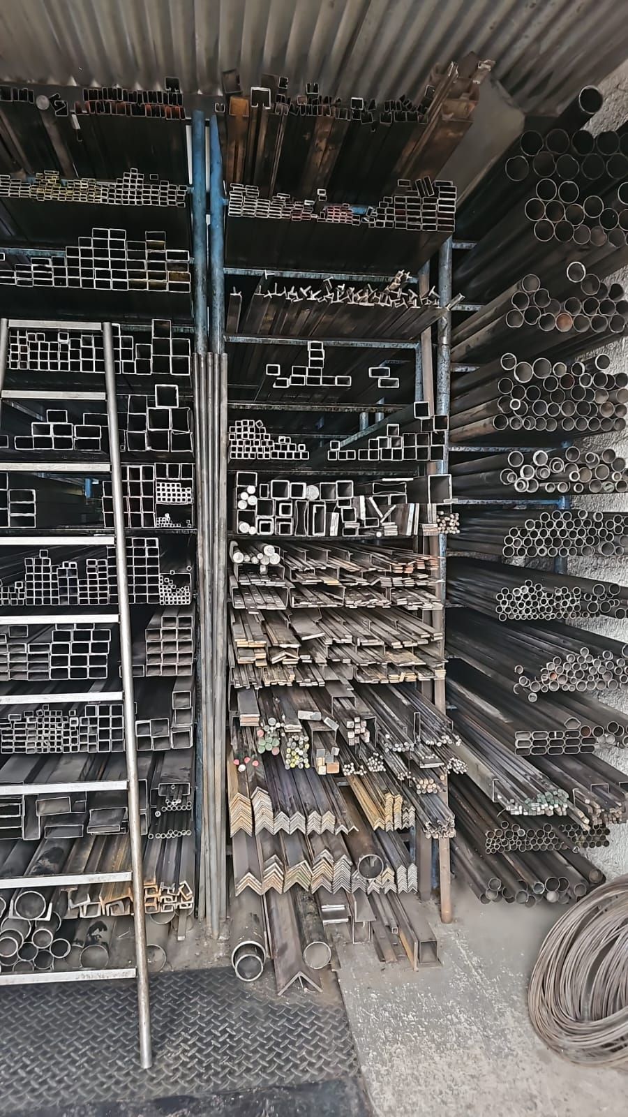 Un almacén lleno de muchos tubos de metal y una escalera.