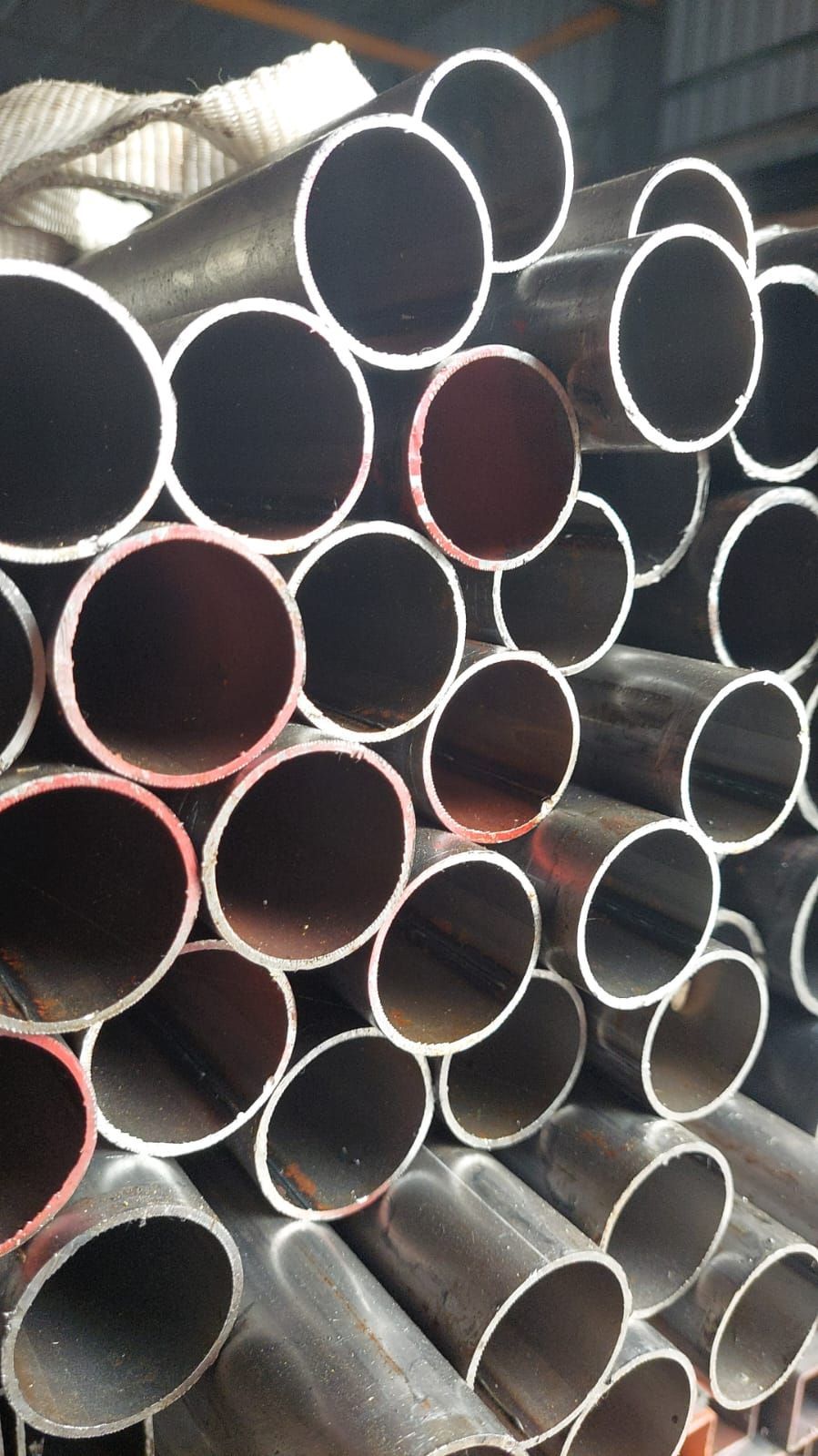 Una pila de tubos de metal apilados uno encima del otro en un almacén.