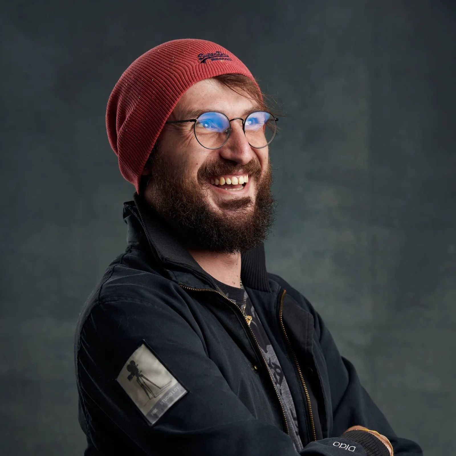 A man with a beard wearing a red beanie and glasses