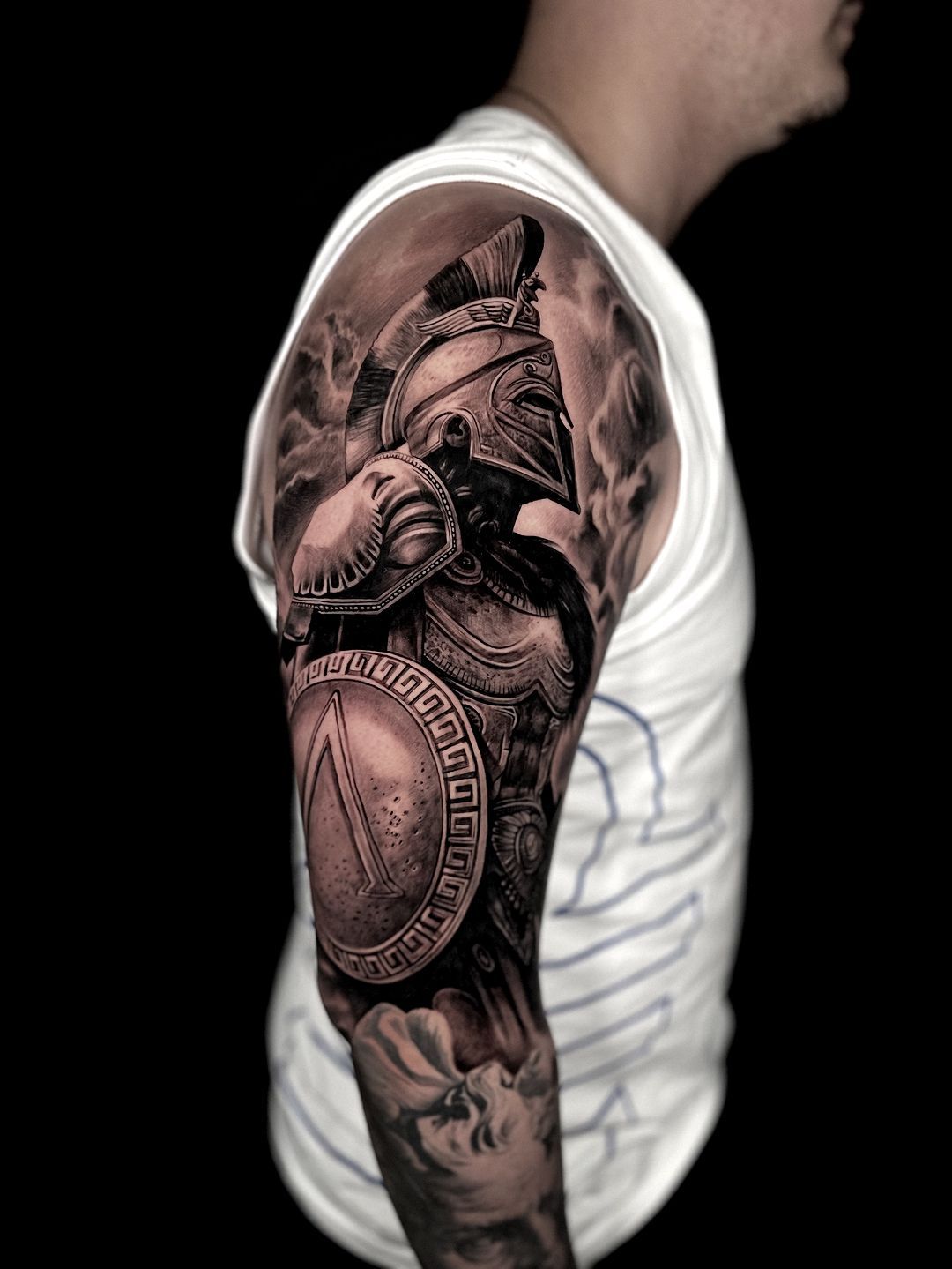 A man has a tattoo of a warrior on his arm.