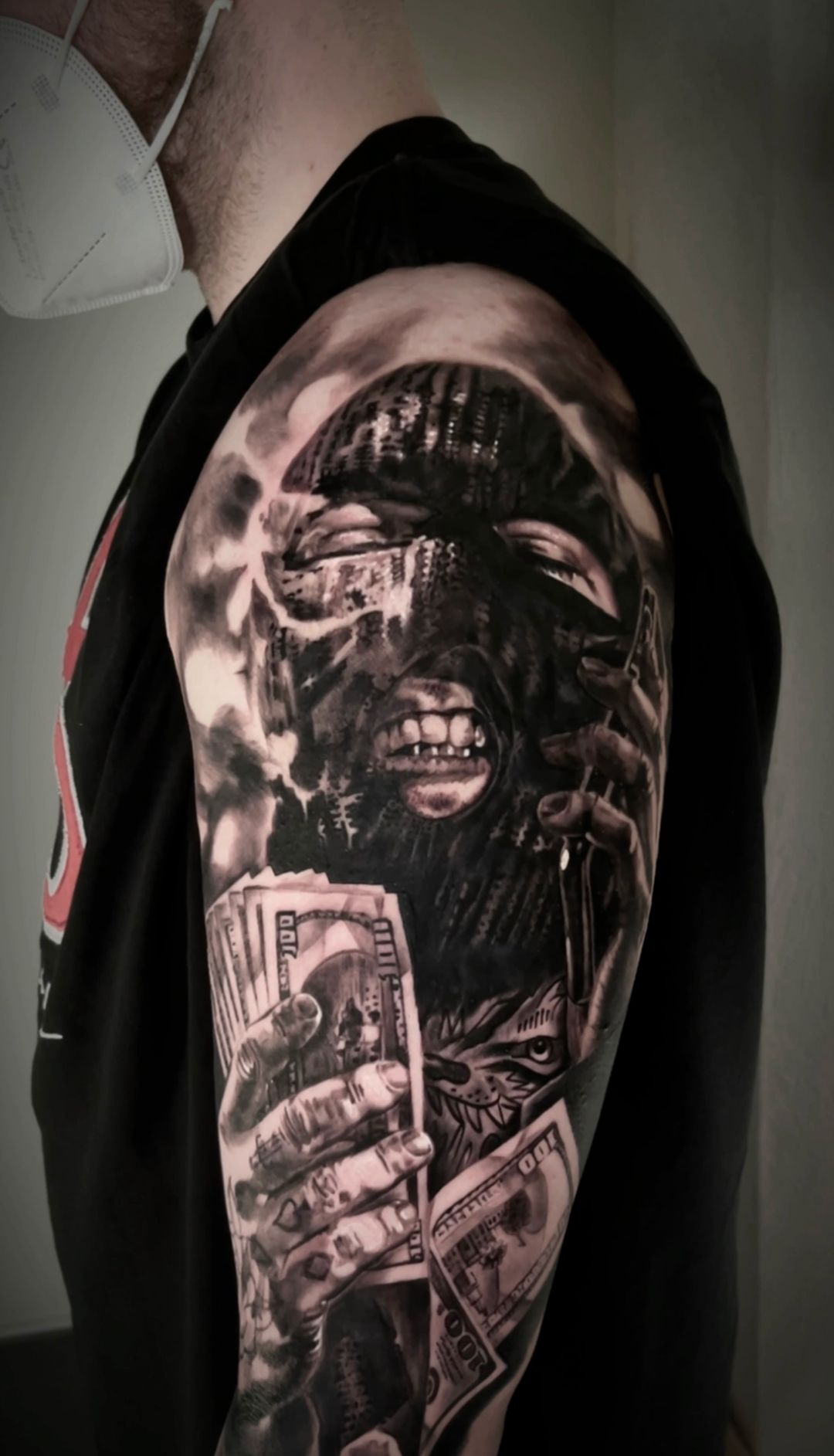 A man is wearing a mask and has a tattoo on his arm.