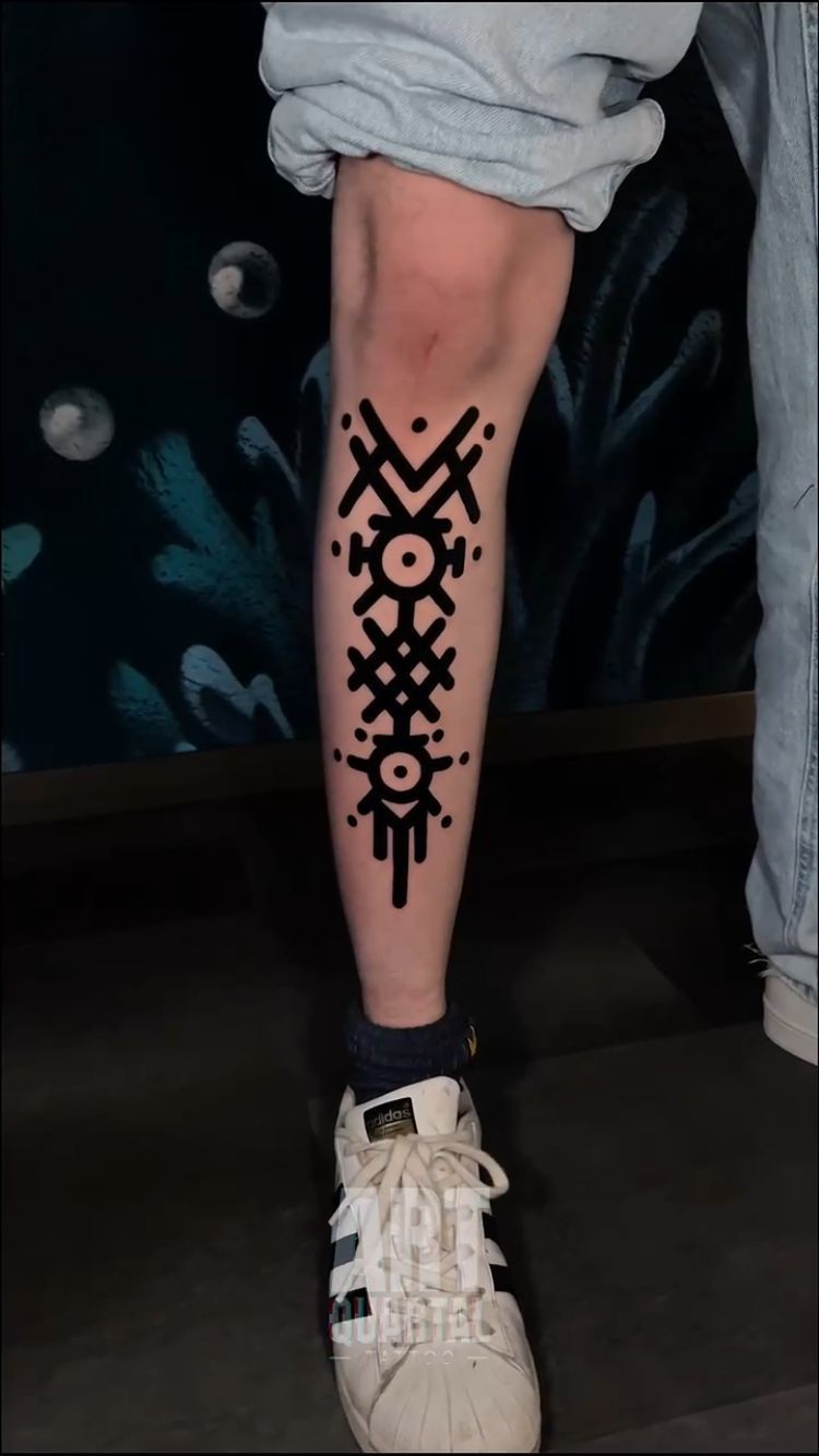 A person with a black tattoo on their leg