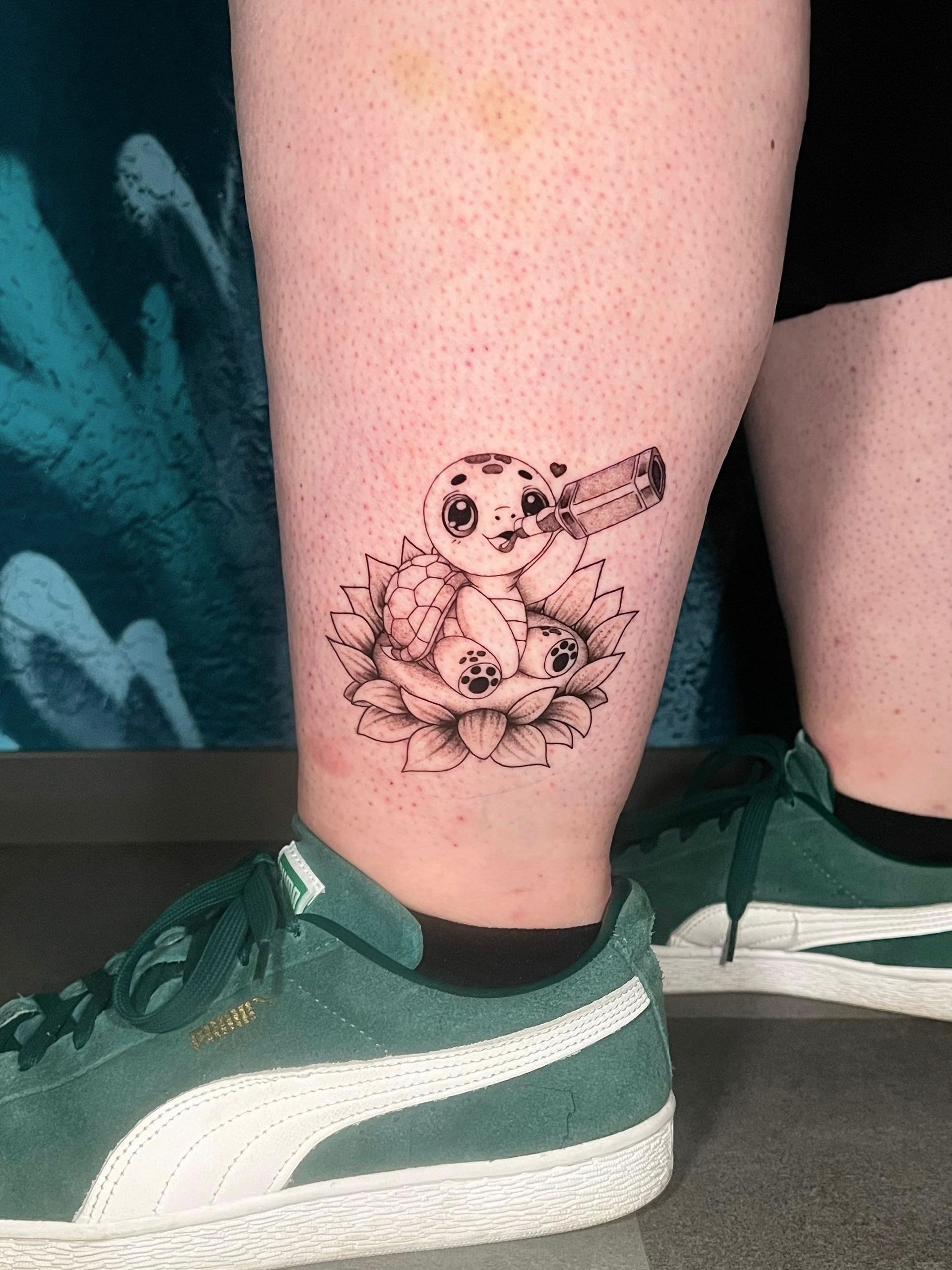 A person has a tattoo of an owl on their leg.