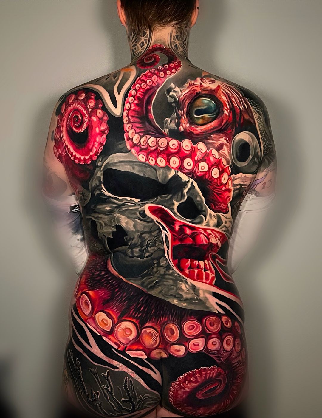 A woman with a skull and octopus tattoo on her back.