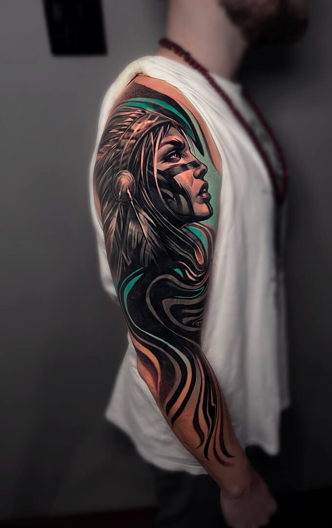 A man with a native american tattoo on his arm.
