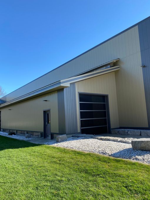 Beige industrial warehouse with a black loading dock door