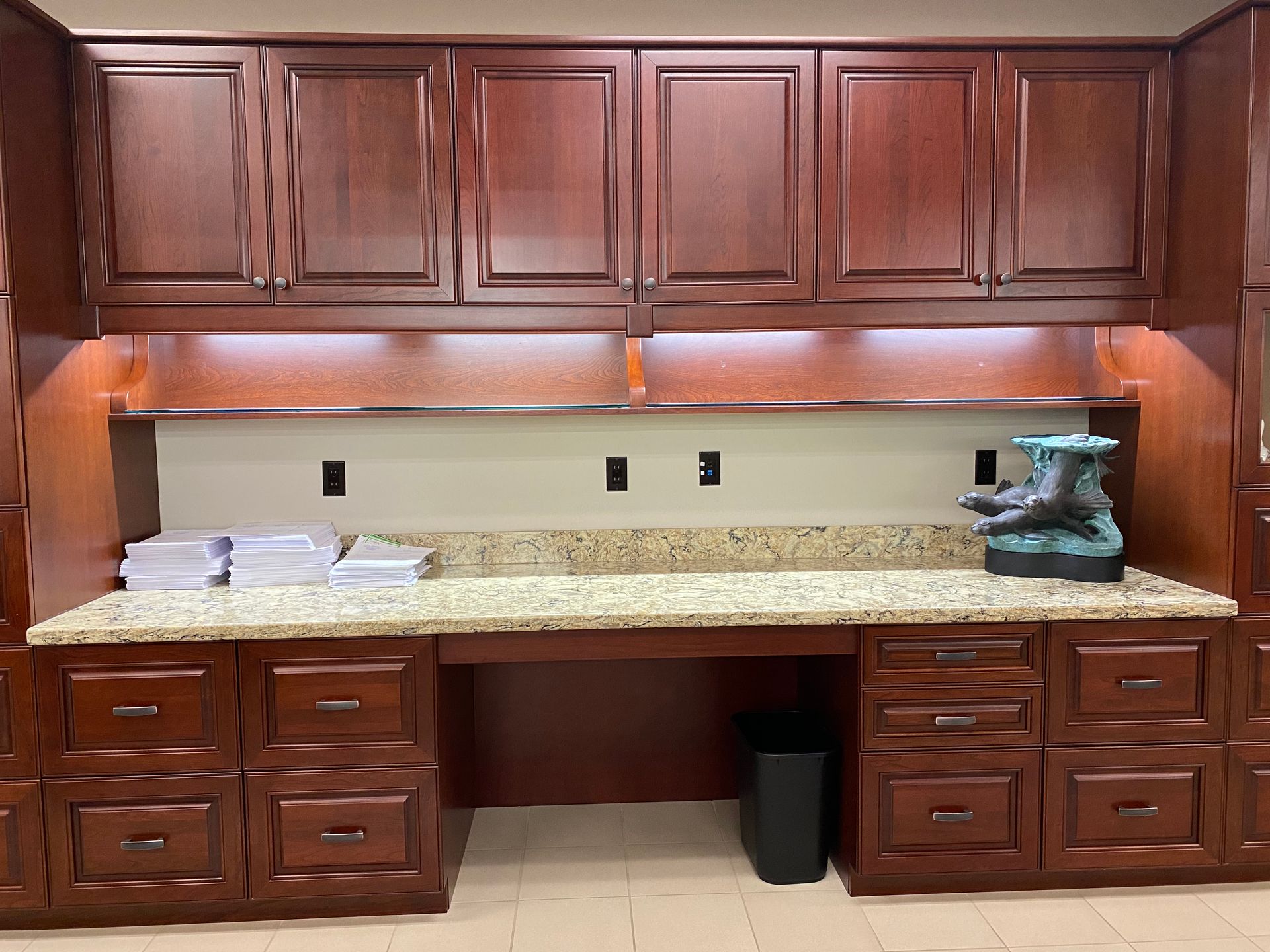 Cherry wood storage cabinets, granite countertop, and decorative teapot on the right side.