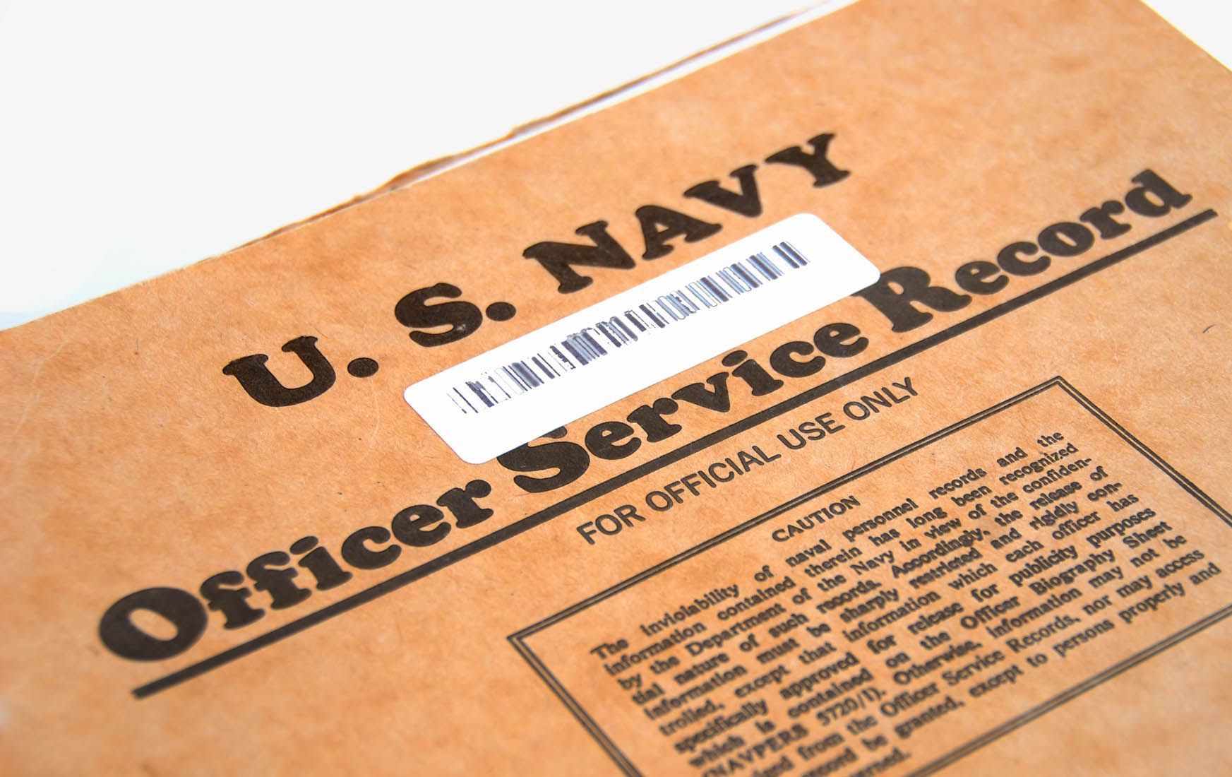 U.S. Navy officer service record folder in tan, angled view with bold black text