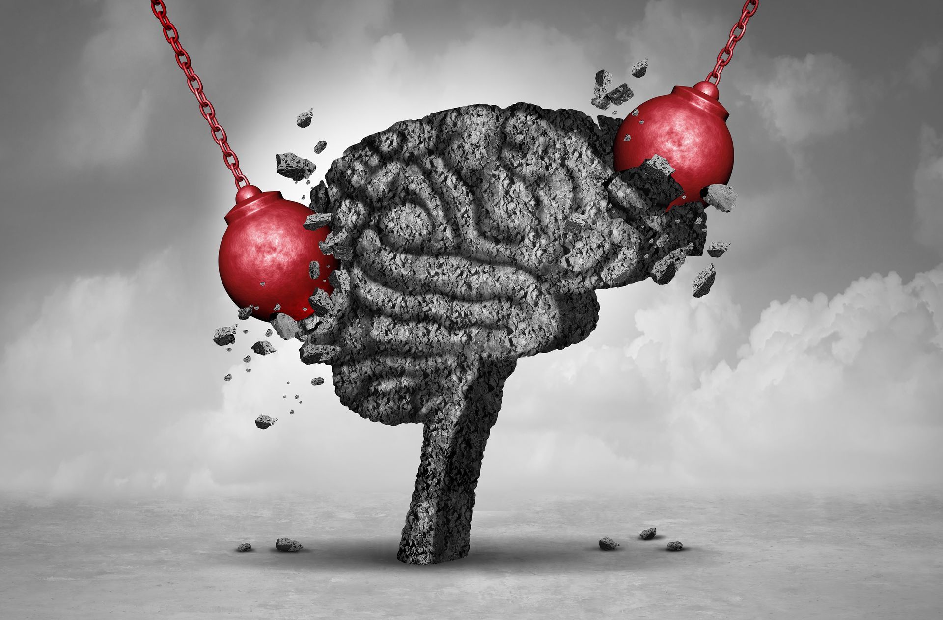 Gray brain suspended by red chains over a barren landscape