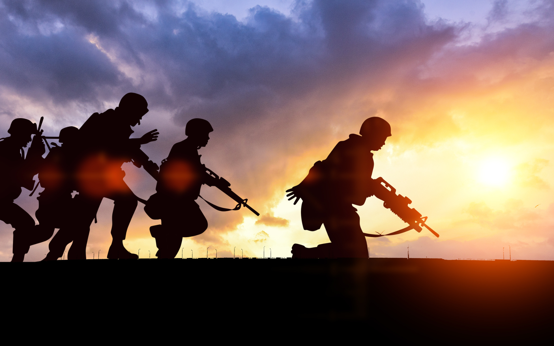 Silhouetted soldiers advancing with rifles at sunset under a dramatic orange-purple sky