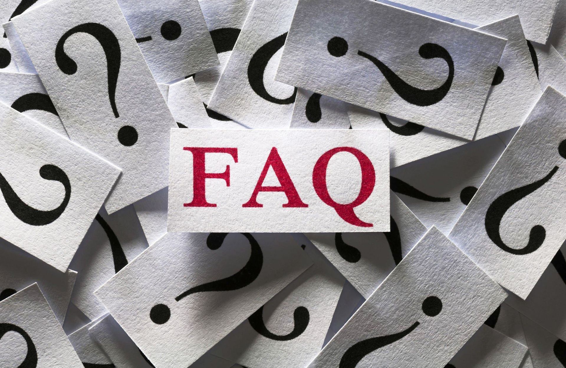 FAQ text over a pile of paper question marks