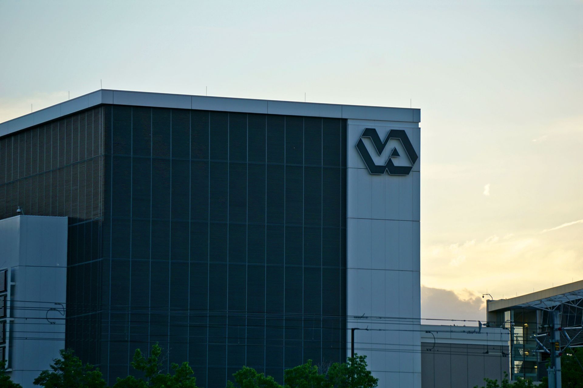 Modern office building with a large logo on the facade at sunset