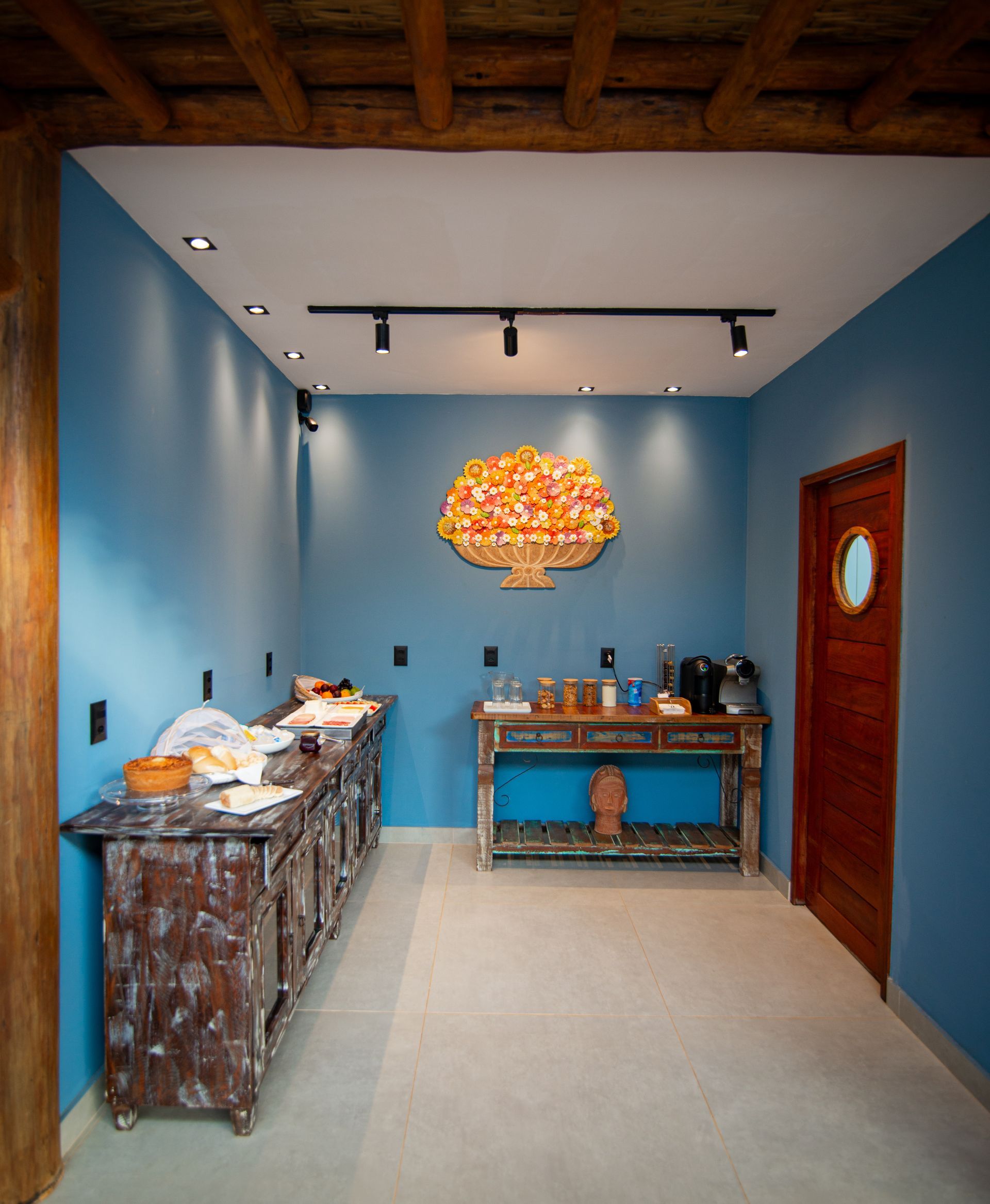 Uma sala com paredes azuis e uma mesa de madeira Pousada Xica