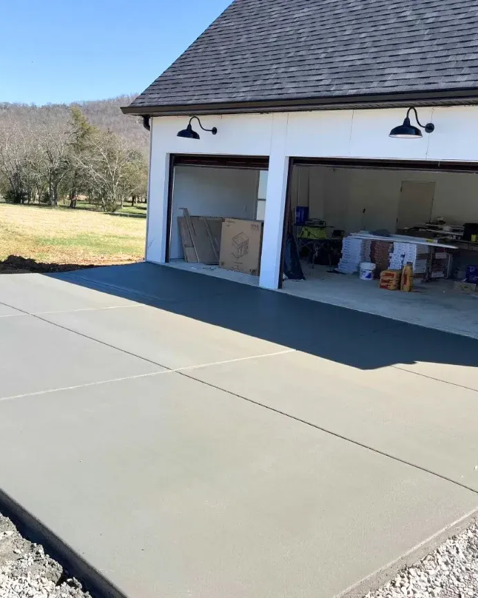 An empty barn with a concrete floor and a wooden roof. Project done by Raise the Bar Construction