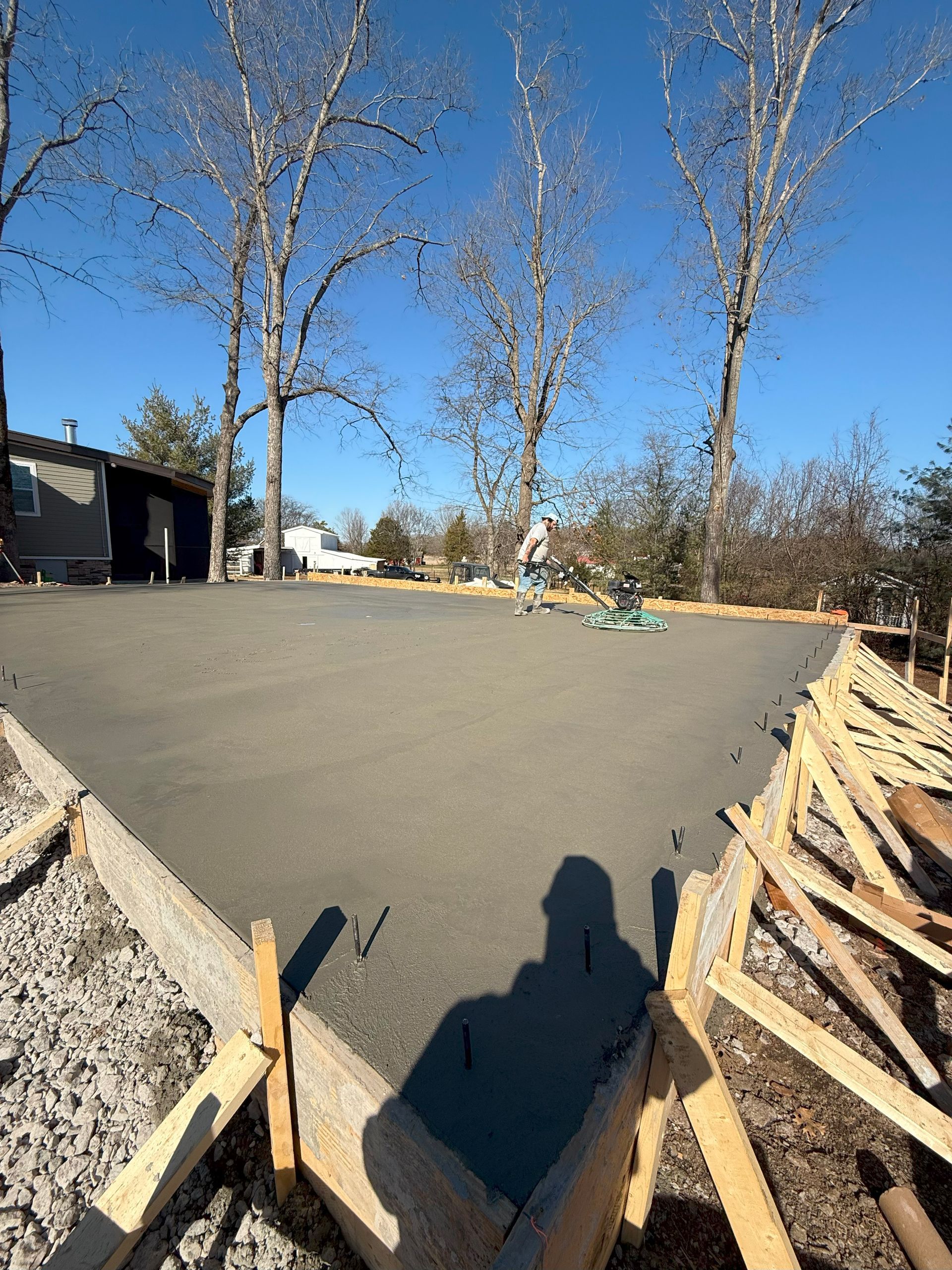 A shadow of a person is cast on a concrete surface.