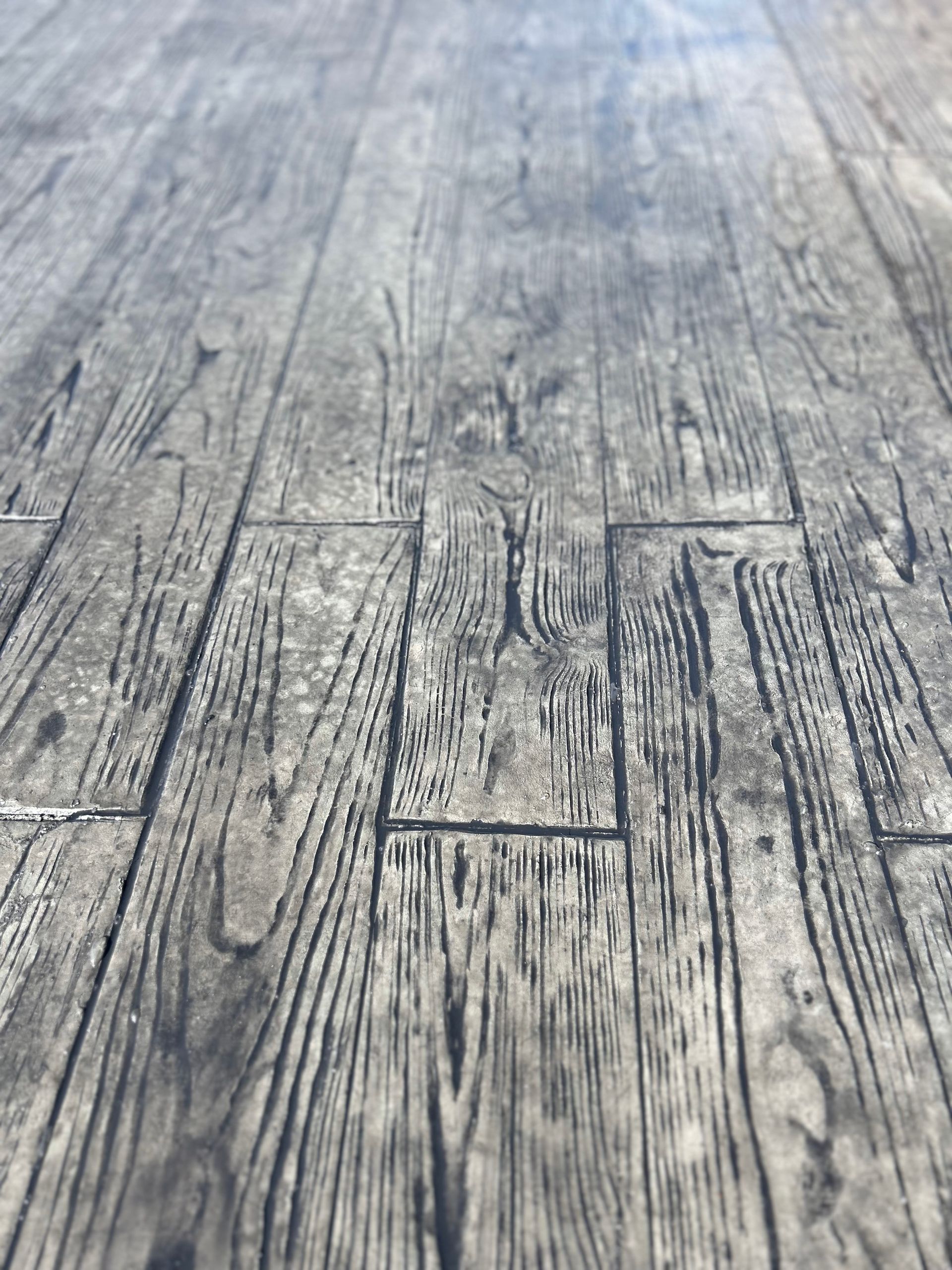 Weathered gray wooden tabletop with visible grain and cracks, viewed from above