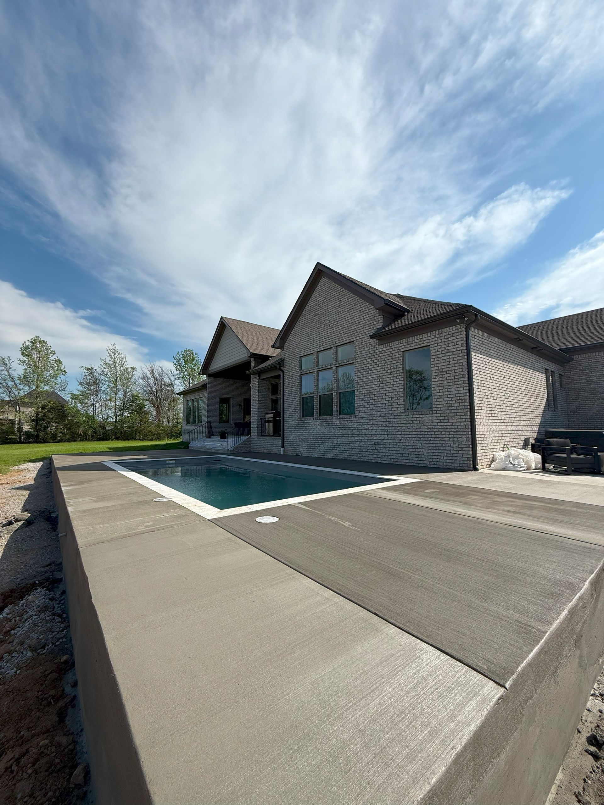 A large house with a large swimming pool in front of it.