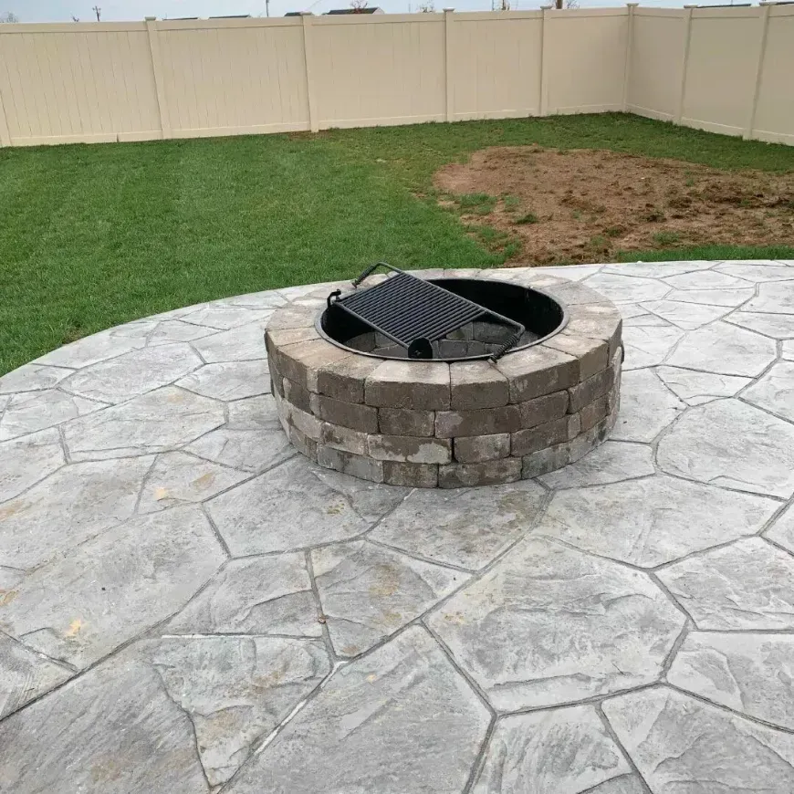 A fire pit is sitting on top of a concrete patio.
