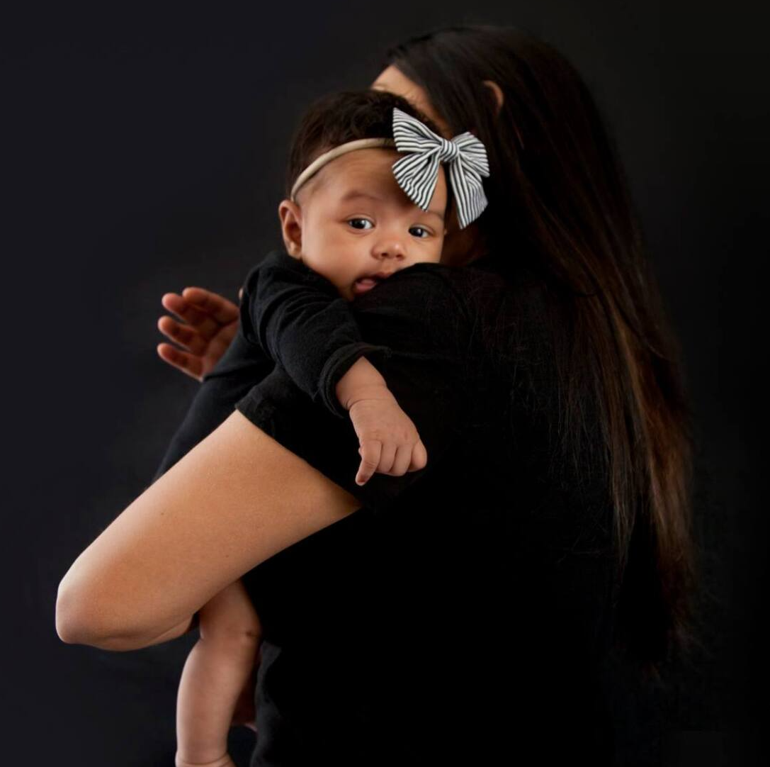Mother holds baby, black background Total Creative, photography in Auckland
