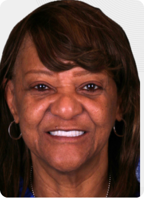 Woman smiling, dark hair with bangs, hoop earrings, and a blue shirt.