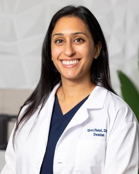 Woman in white lab coat smiles at camera. Text: Dr. Patal, Dentist.