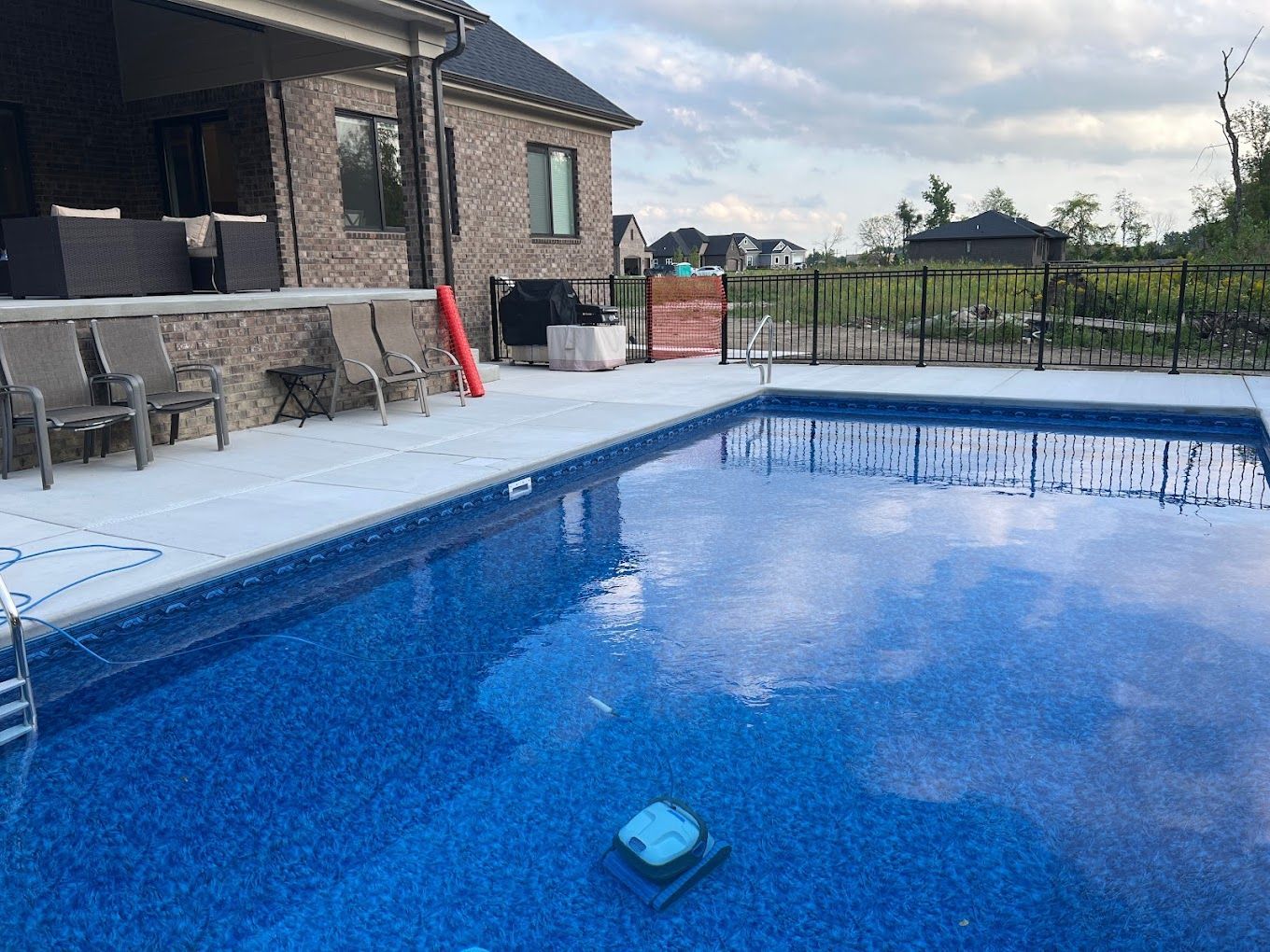 A large swimming pool with a house in the background.