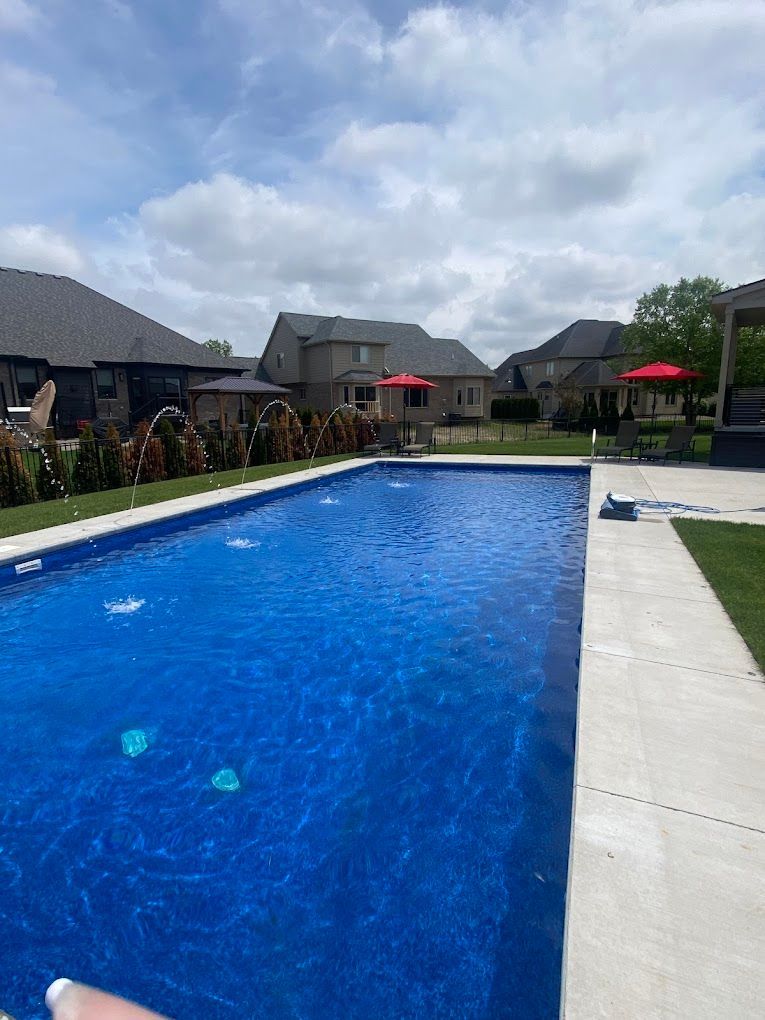 A large swimming pool surrounded by houses on a sunny day.