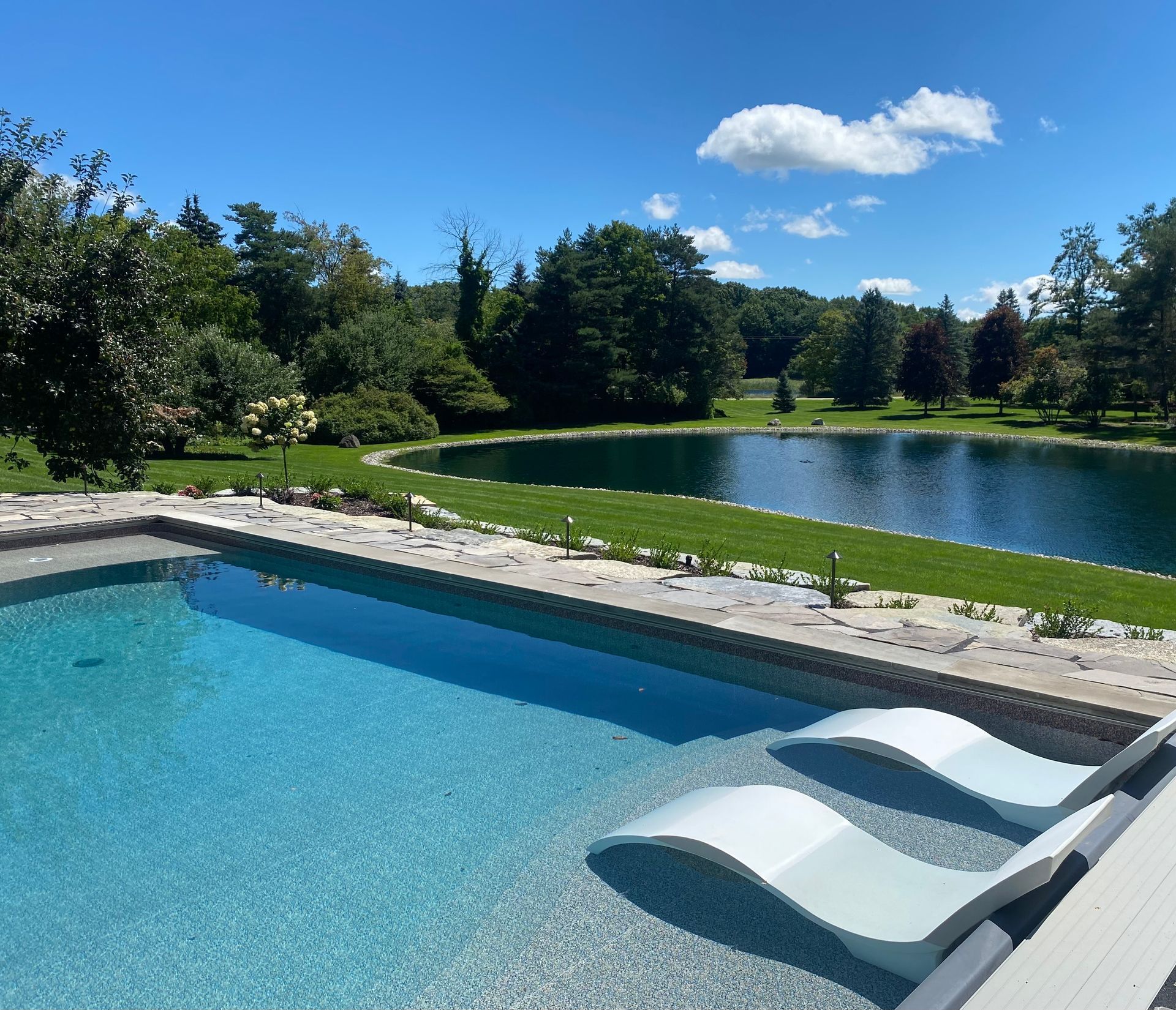 A swimming pool with a lake in the background