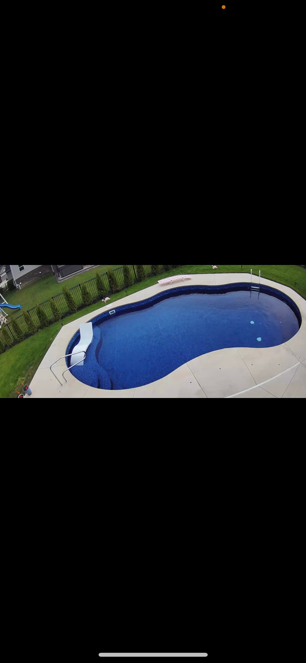 An aerial view of a large swimming pool in a backyard.