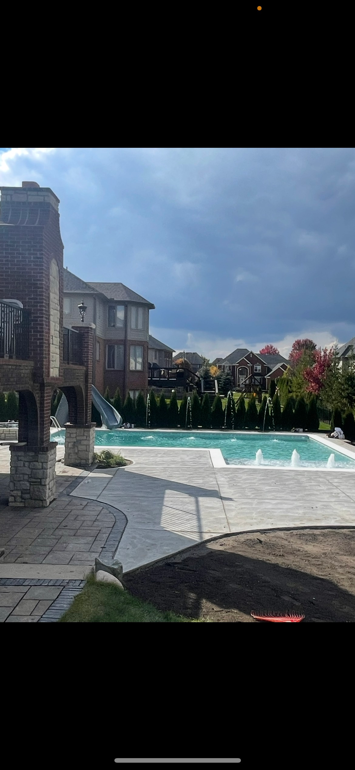 There is a large swimming pool in the backyard of a house.