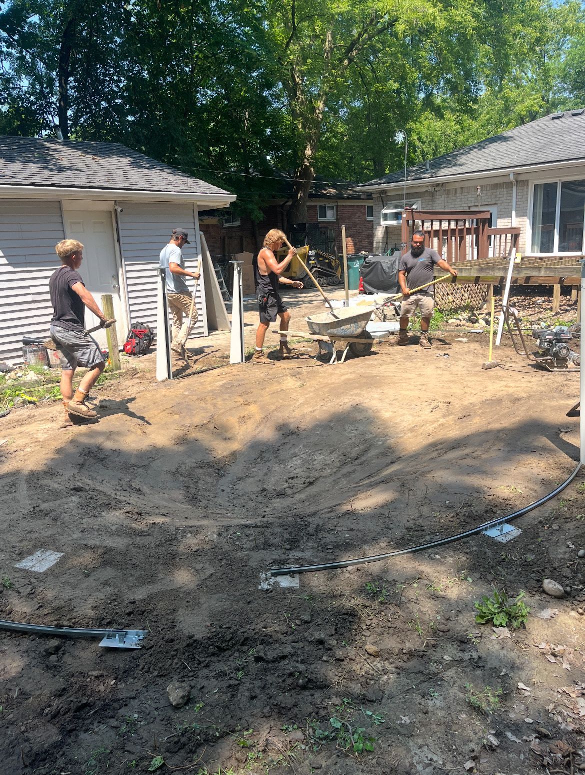 A large swimming pool is being built in a backyard.