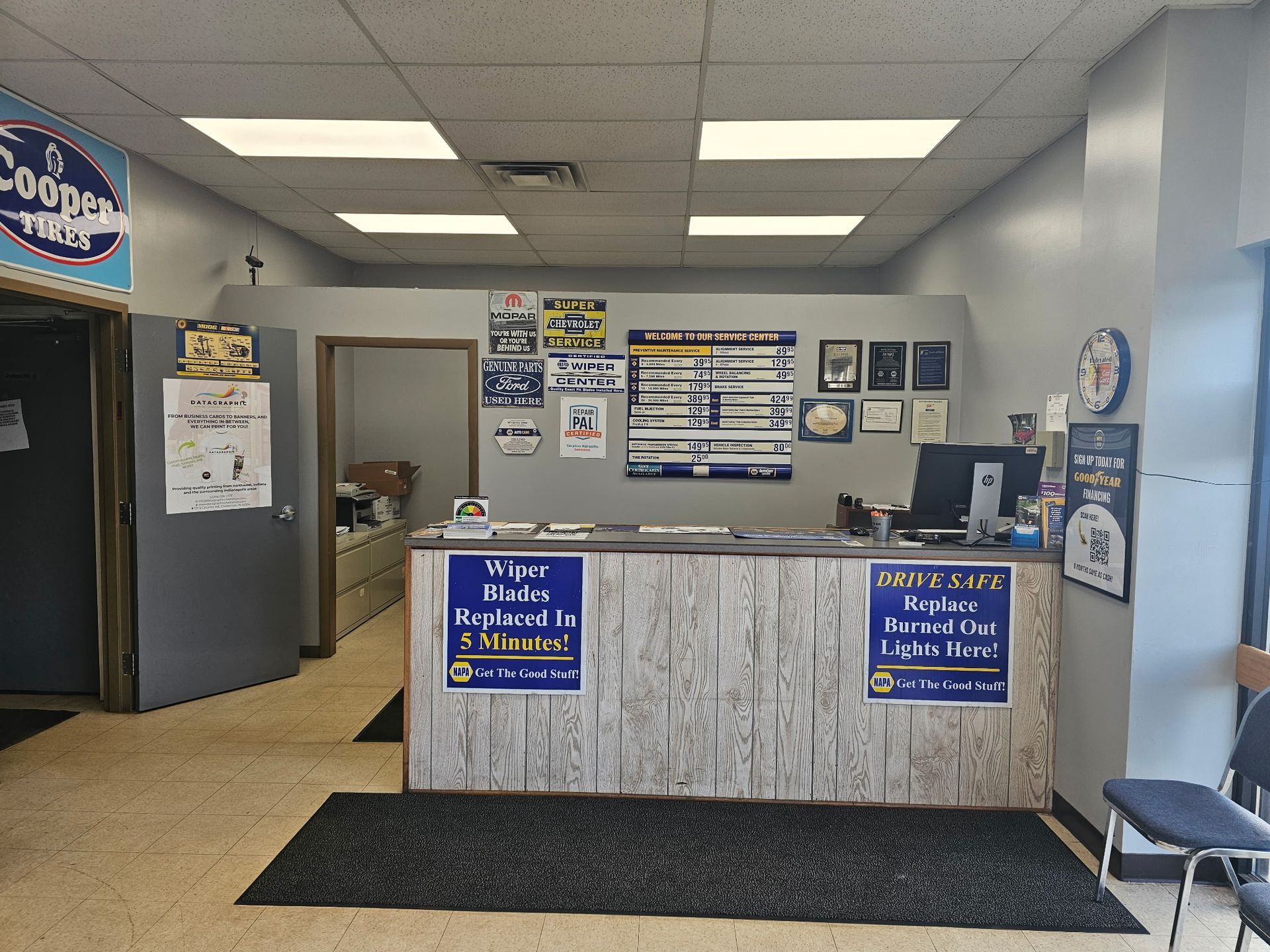 Empty office lobby with reception desk, wall notices, and chairs in blue-gray tones