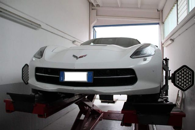 Un'auto sportiva bianca è su un ascensore in un garage