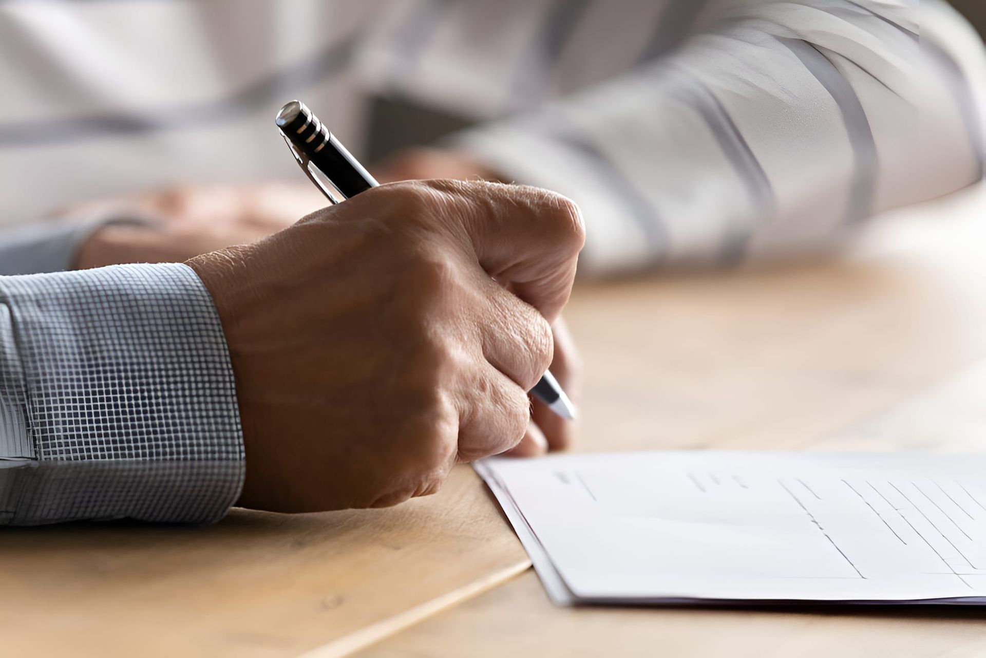 A Man Is Writing On A Piece Of Paper With A Pen — De Silva Hebron In Darwin City, NT