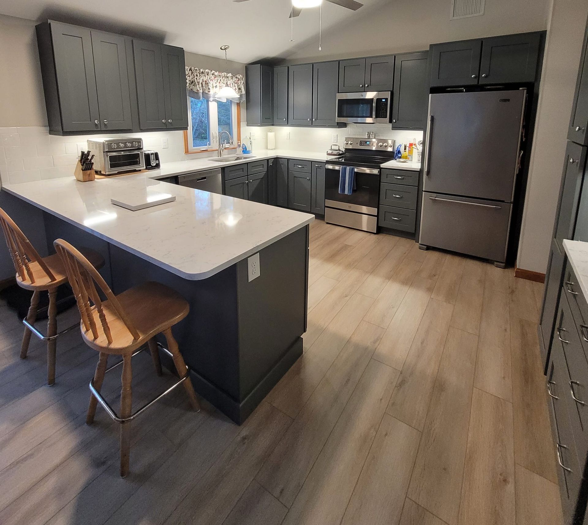 A kitchen with stainless steel appliances and gray cabinets