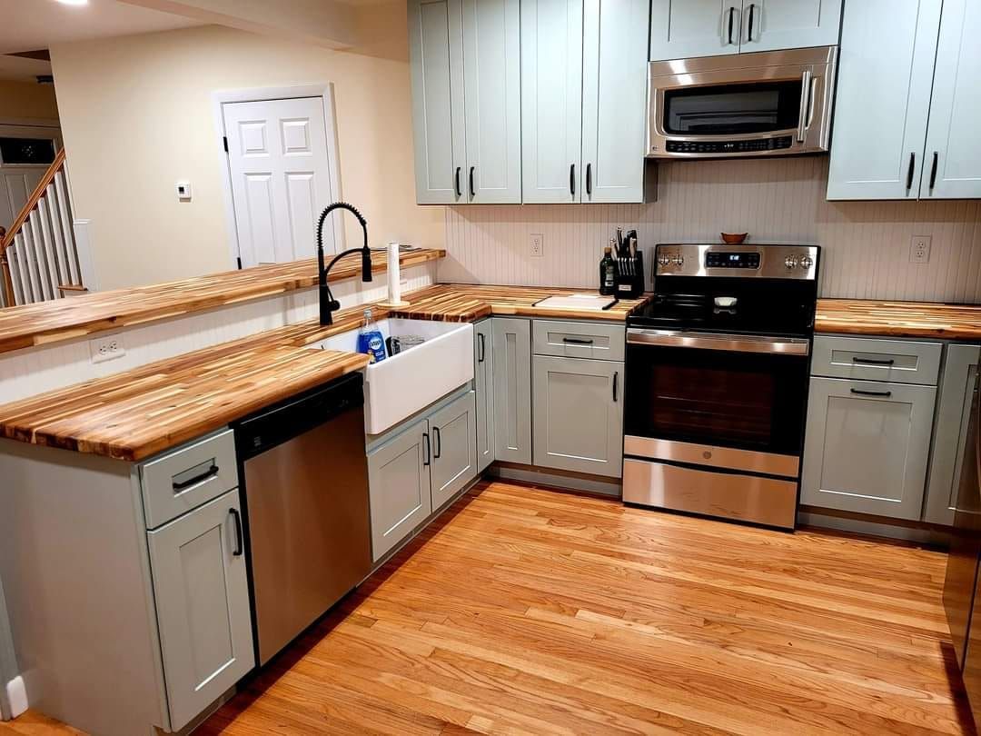 A kitchen with stainless steel appliances and wooden floors.