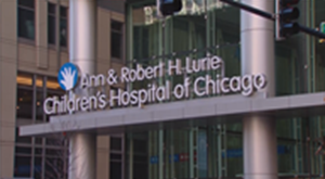 Signage for the Ann & Robert H. Lurie Children's Hospital of Chicago, featuring a blue hand icon on a building exterior.