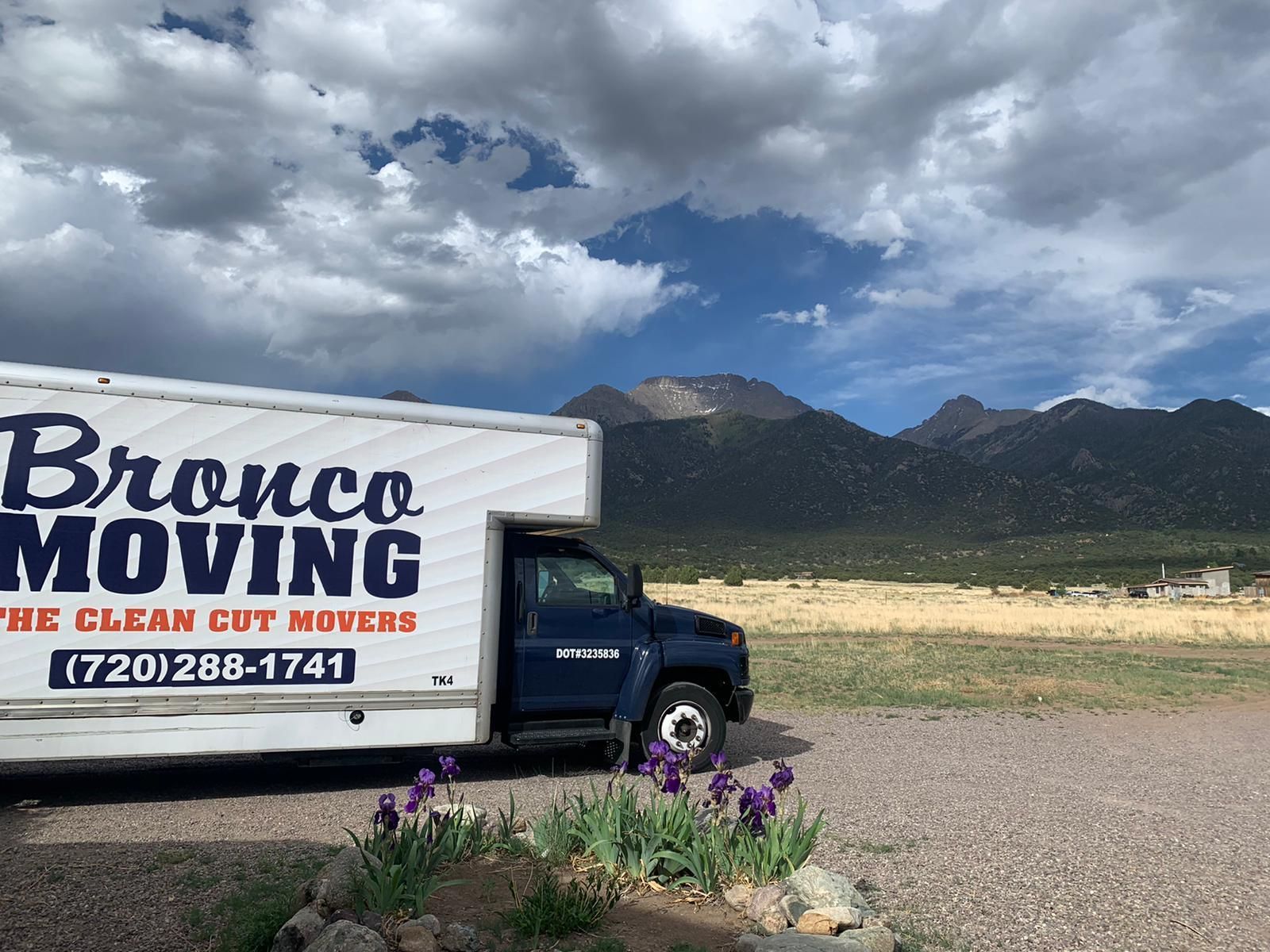 Moving truck with Bronco Moving logo in scenic location.
