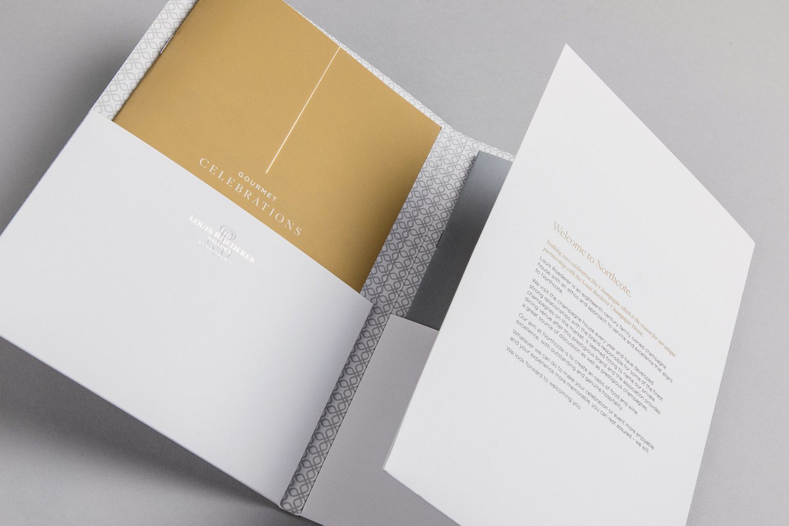 Open white presentation folder with gold interior and printed text.