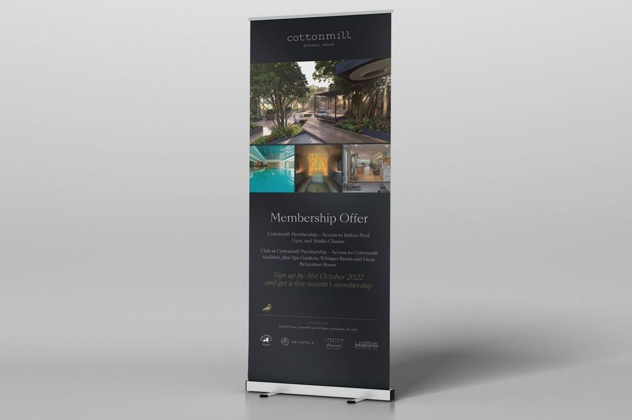 A retractable banner with images of a building and pool, with text against a dark background.