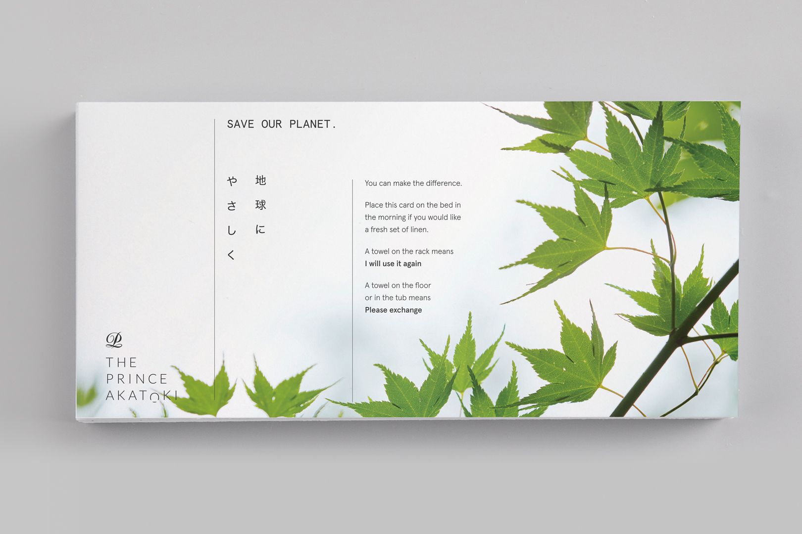 White rectangular sign with green leaves; text on the left, right of the leaves.