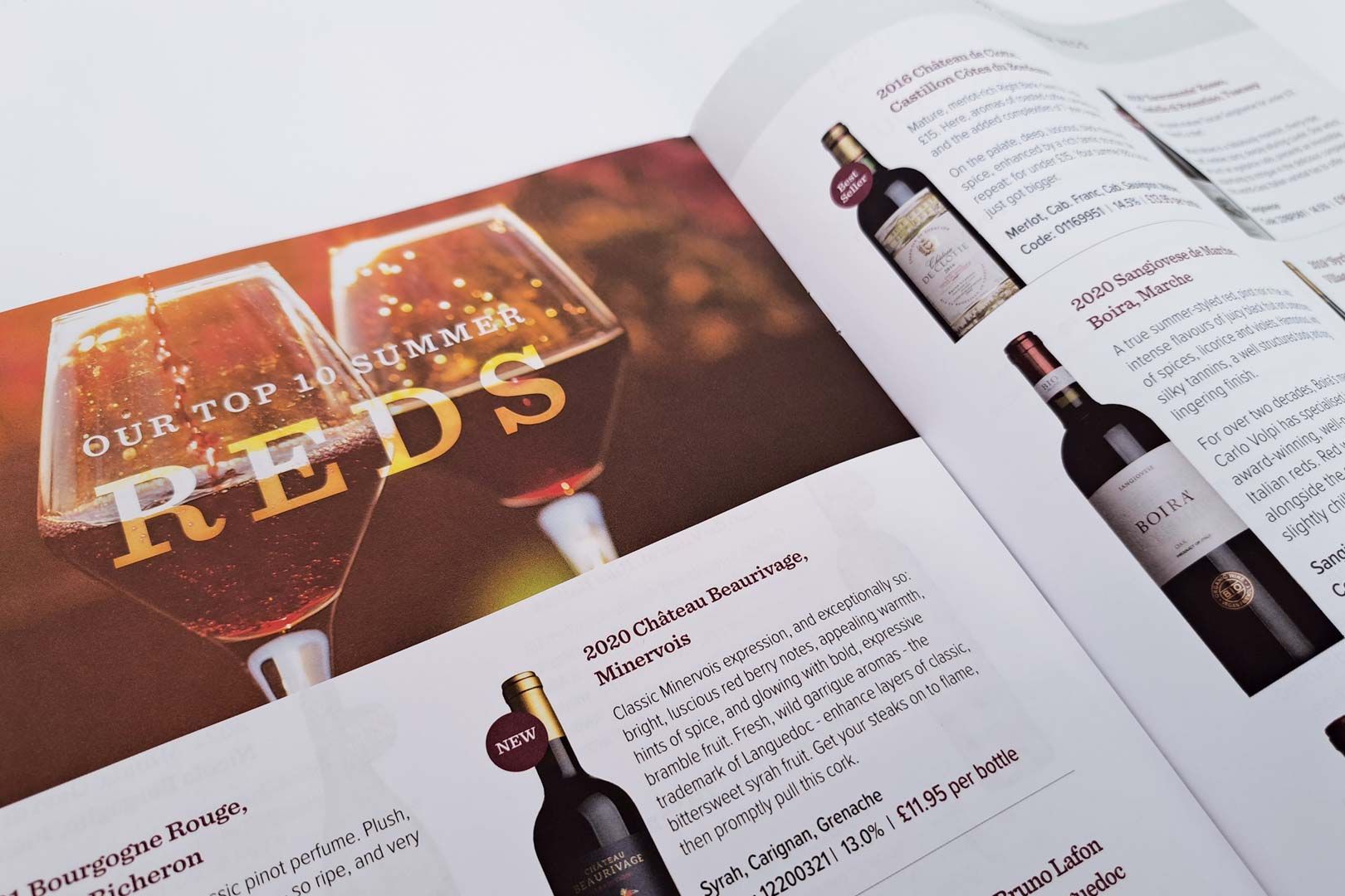 Open magazine spread on reds; two wine glasses with the word 