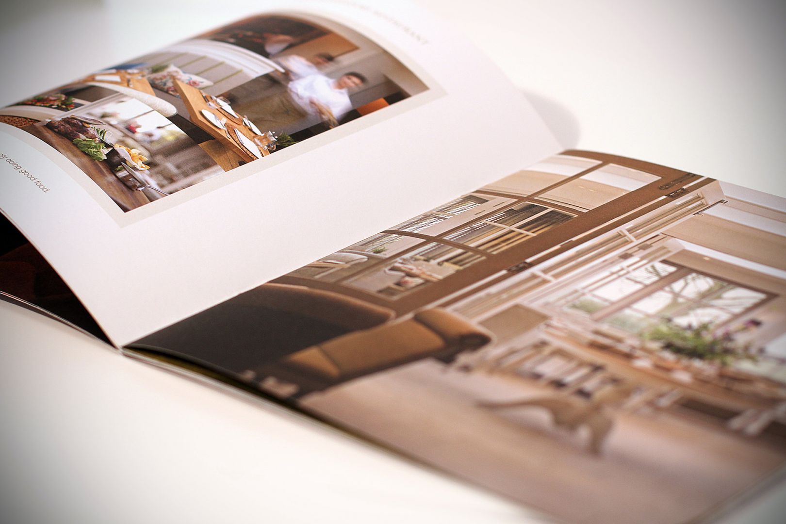 Open magazine, showcasing interior design; kitchen and dining room photos.