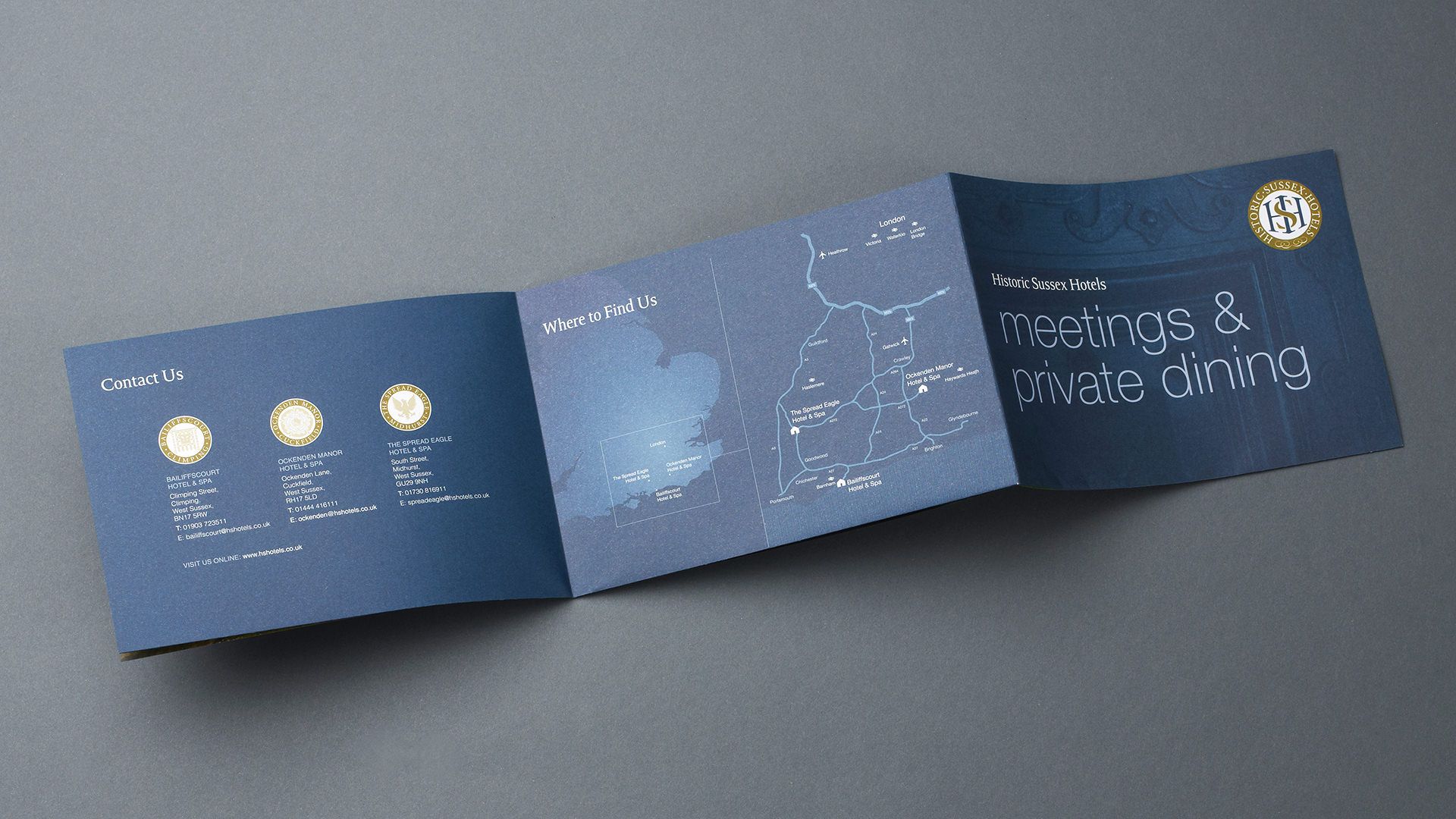 A dark blue, accordion-folded leaflet with white text. The card includes gold accents and a logo on the back.