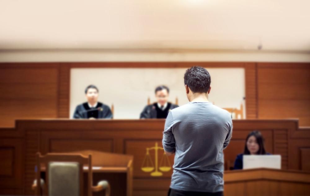 A Man Is Standing In Front Of A Judge— Clarence Valley Legal In Grafton, NSW