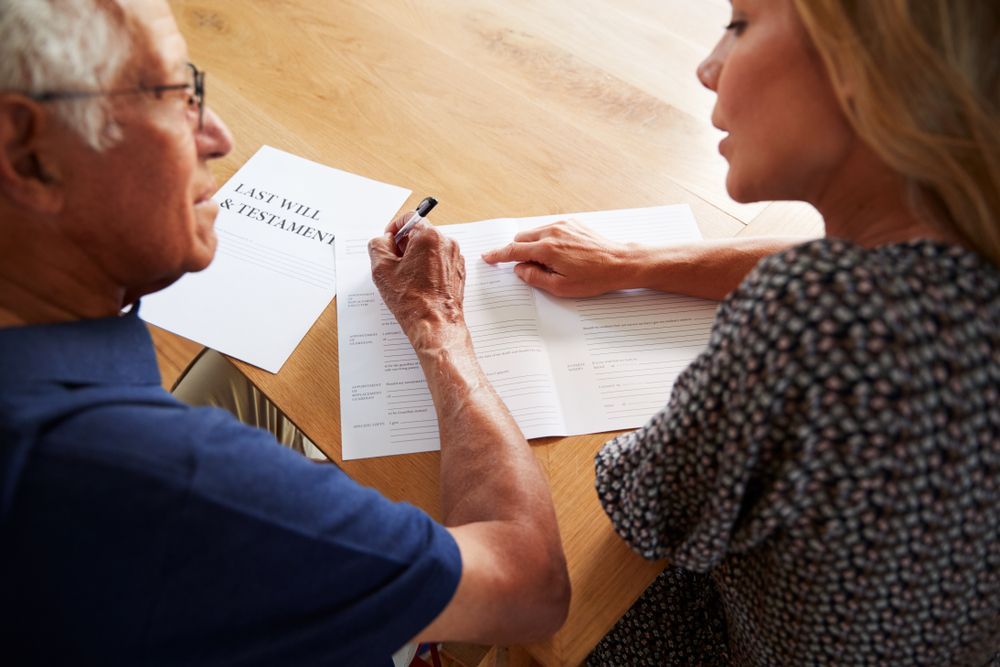 A Man Signing A Document — Clarence Valley Legal In Grafton, NSW