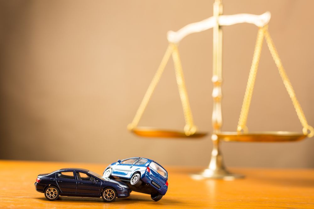 Two Toy Cars Are Sitting On A Wooden Table — Clarence Valley Legal In Grafton, NSW