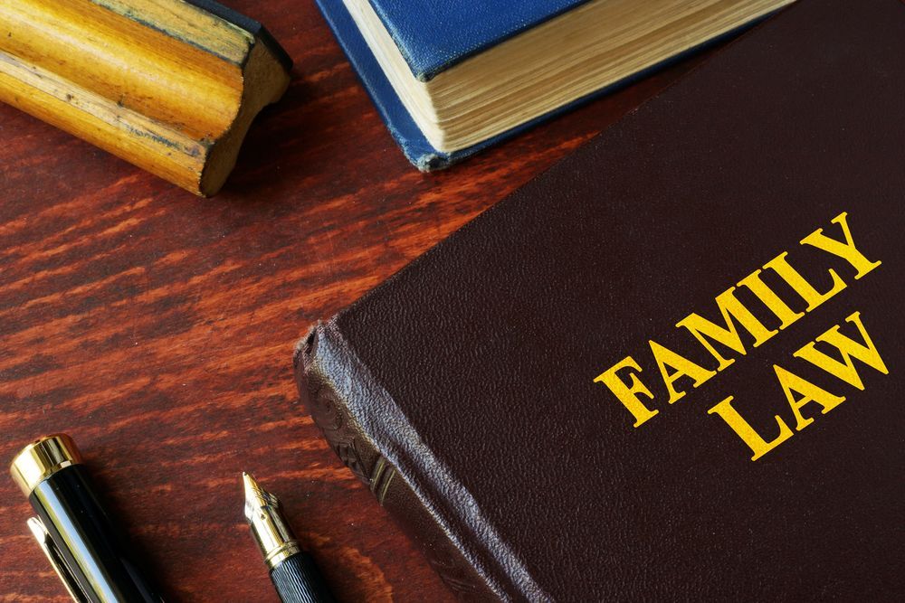 A Family Law Book Is Sitting Next To A Pen — Clarence Valley Legal In Grafton, NSW