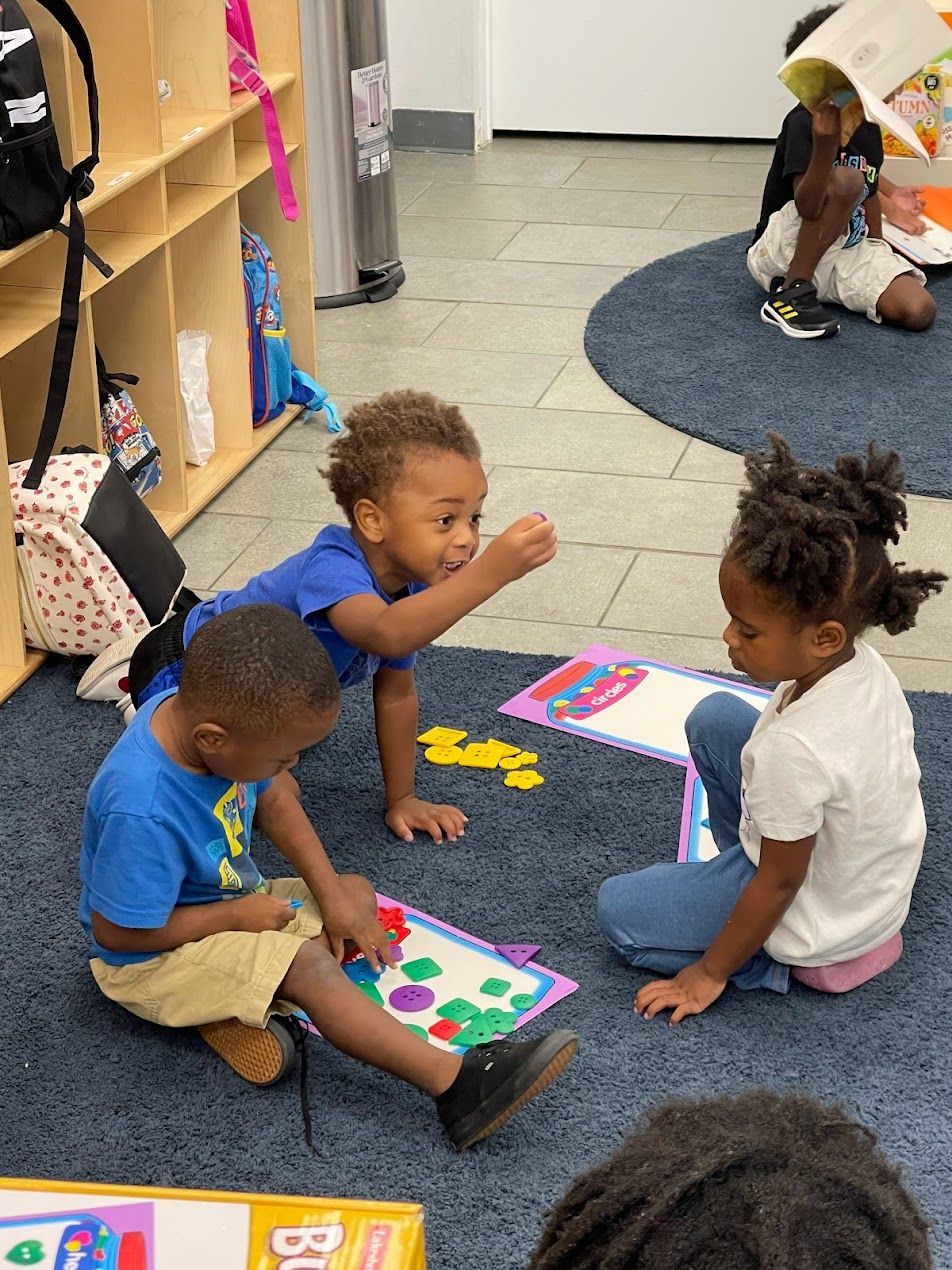 A group of children are sitting on the floor playing with puzzles.