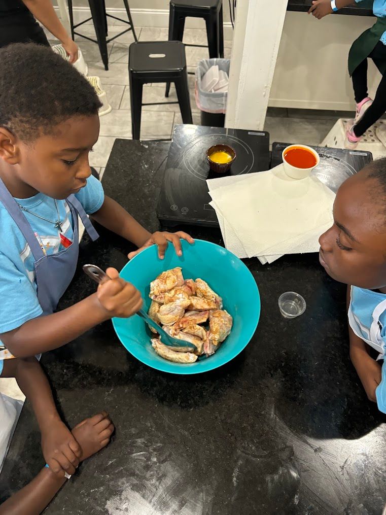 Two children are sitting at a table eating food from a bowl.